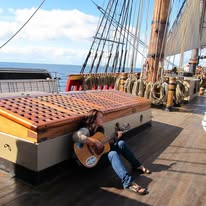 Playing guitar on the ship's deck